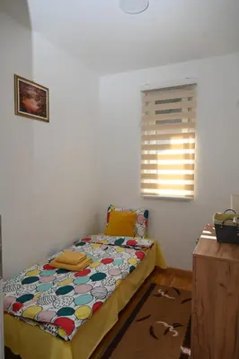 a bedroom with a bed in a room with a window at Apartman A&A lux in Vrnjačka Banja