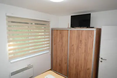 a room with a television and a wooden cabinet at Apartman A&A lux in Vrnjačka Banja
