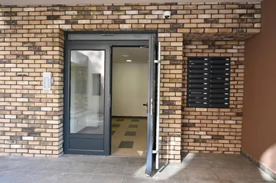 an entrance to a brick building with a black door at Apartman A&A lux in Vrnjačka Banja