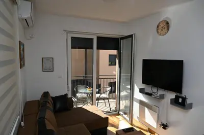 a living room with a couch and a flat screen tv at Apartman A&A lux in Vrnjačka Banja