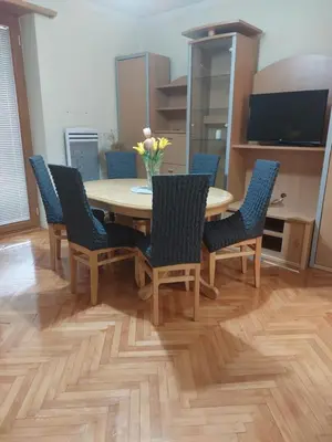 a dining room table and chairs with a vase of flowers at Apartman La Viva Sokobanja in Soko Banja