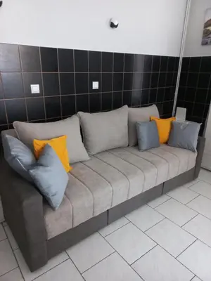 a couch with colorful pillows on it in a room at Studio apartman Beus in Kuršumlija