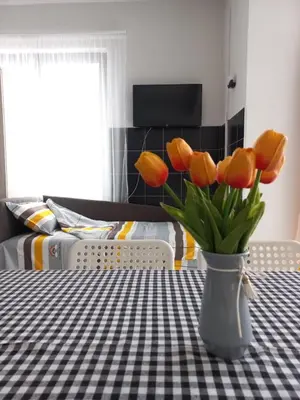 a vase of orange tulips sitting on a table at Studio apartman Beus in Kuršumlija