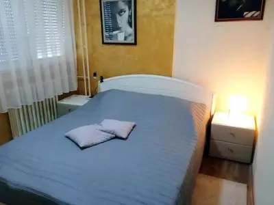 a bedroom with a bed with two pillows on it at LUX Apartman in Leskovac