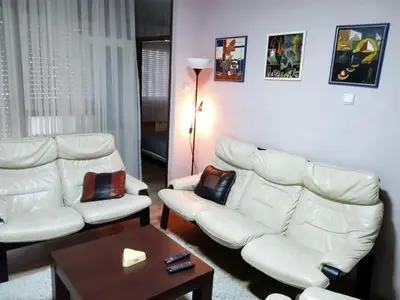 a living room with two white couches and a table at LUX Apartman in Leskovac