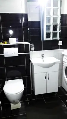 a black and white bathroom with a toilet and a sink at LUX Apartman in Leskovac