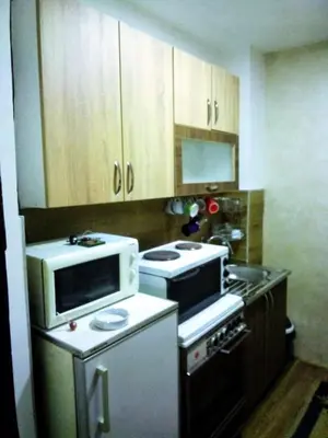 a kitchen with a microwave and a stove at LUX Apartman in Leskovac