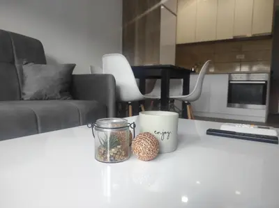 a table with two mugs and a candle on it at Cera premium apartment in Soko Banja