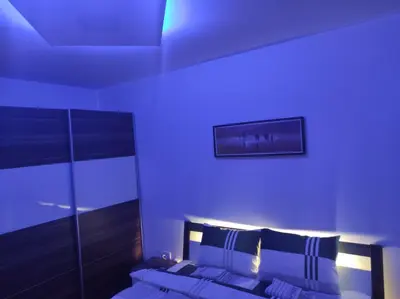 a bedroom with a bed with a blue light at Cera premium apartment in Soko Banja