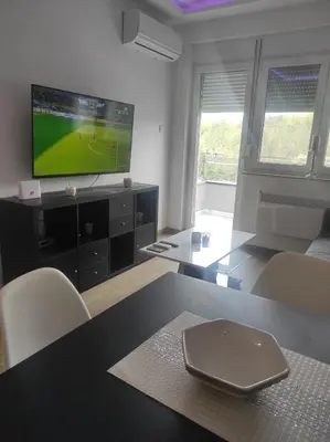 a living room with a flat screen tv and a table at Cera premium apartment in Soko Banja