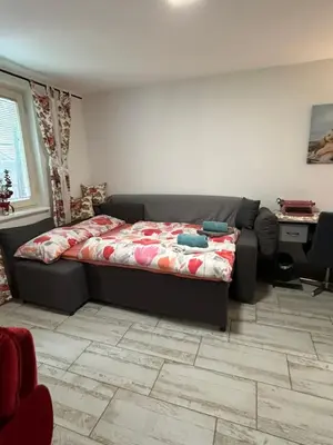 a bedroom with a bed and a couch and a desk at Apartmani Milanović Jagodina in Jagodina
