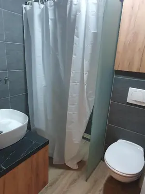 a bathroom with a white shower curtain and a toilet at Residence hill Studio Rocco in Kopaonik