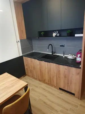 a kitchen with a sink and a wooden table at Residence hill Studio Rocco in Kopaonik