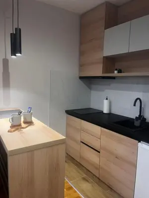 a kitchen with wooden cabinets and a black counter top at Studio Vera in Kruševac