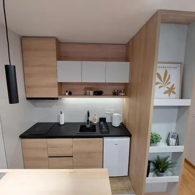 a kitchen with a black counter top and wooden cabinets at Studio Vera in Kruševac