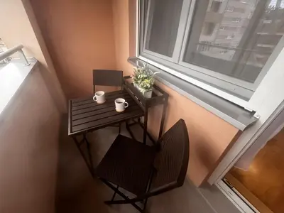a small table and a chair next to a window at Studio Vera in Kruševac
