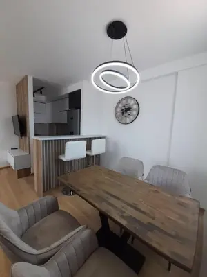 a dining room with a wooden table and chairs at Apartman Petra in Niš