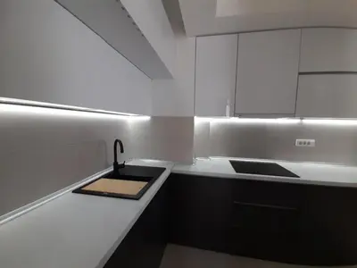 a white kitchen with a sink and a counter at Apartman Petra in Niš