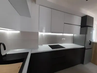 a kitchen with white cabinets and a refrigerator at Apartman Petra in Niš