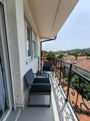 a balcony with two chairs and a view of the city at Apartman Petra in Niš