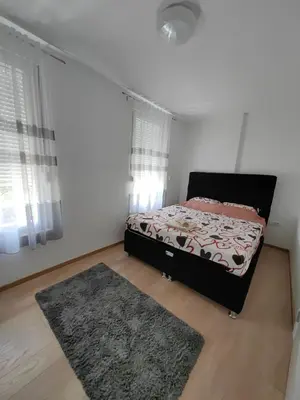a bedroom with a bed and a rug at Apartman Petra in Niš
