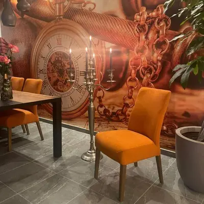 a room with a table and a clock on the wall at Rezidencija Arion in Kraljevo