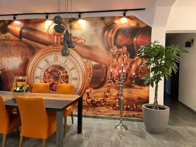 a dining room with a large clock on the wall at Rezidencija Arion in Kraljevo