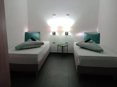 a room with two beds and a light on the wall at Rezidencija Arion in Kraljevo