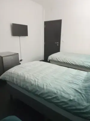 a bedroom with two beds and a dresser and a bed sidx sidx sidx at Rezidencija Arion in Kraljevo