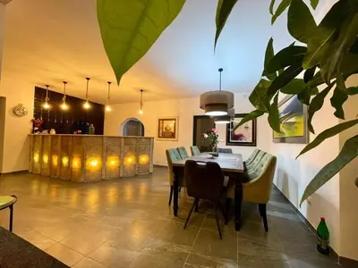 a dining room with a table and chairs and a bar at Rezidencija Arion in Kraljevo