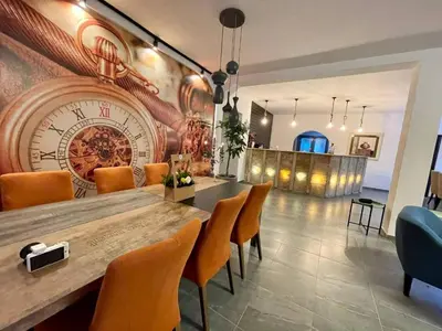 a dining room with a large clock on the wall at Rezidencija Arion in Kraljevo