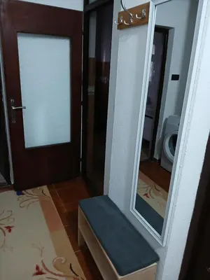 a bathroom with a mirror and a bench in front of a door at Apartman AM Mladenović in Vranje