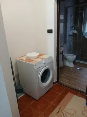 a washing machine in a bathroom with a toilet at Apartman AM Mladenović in Vranje