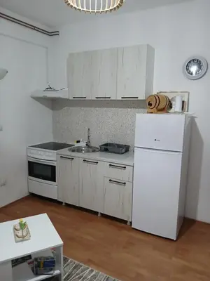 a kitchen with white cabinets and a white refrigerator at Apartman AM Mladenović in Vranje