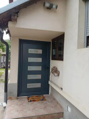 a blue door on the side of a house at Apartman AM Mladenović in Vranje