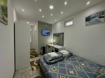 a bedroom with a bed and a sink and a mirror at Villa Veljković - Sobe & apartmani 