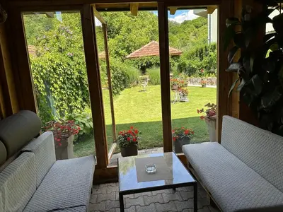 a screened in porch with two chairs and a table at Villa Veljković - Sobe & apartmani 