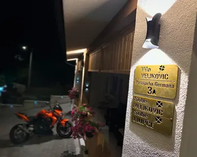 a sign on the side of a building with a motorcycle at Villa Veljković - Sobe & apartmani 