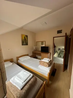 a bedroom with two beds and a mirror at Villa Veljković - Sobe & apartmani 