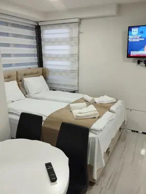 two beds in a room with a tv on the wall at Lela lux in Jošanička Banja