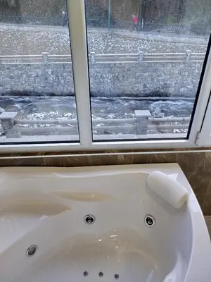 a bath tub in a bathroom with a window at Lela lux in Jošanička Banja