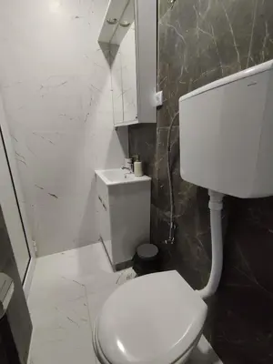 a bathroom with a white toilet and a mirror at Lela lux in Jošanička Banja