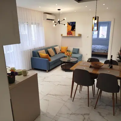 a living room with a blue couch and a table at Cera luxe apartment 2 in Soko Banja