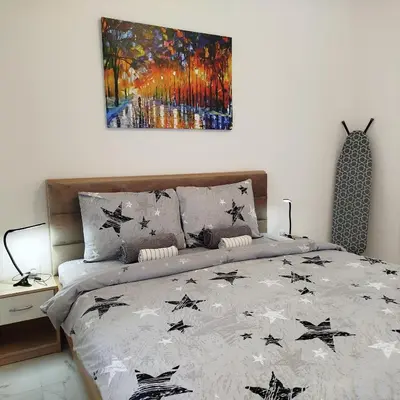 a bed in a bedroom with a painting on the wall at Cera luxe apartment 2 in Soko Banja