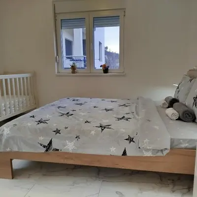 a bed with a comforter on it in a bedroom at Cera luxe apartment 2 in Soko Banja