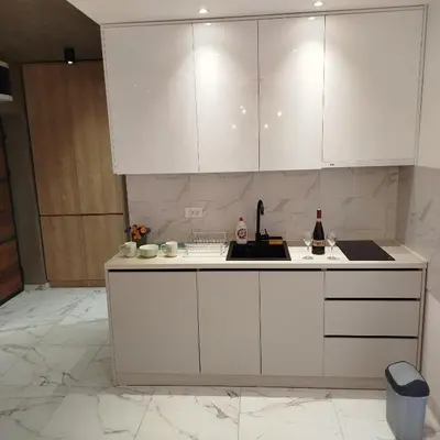 a white kitchen with white cabinets and a sink at Cera luxe apartment 2 in Soko Banja