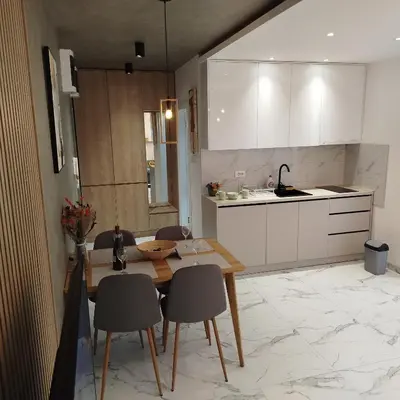 a kitchen with a wooden table and chairs in a room at Cera luxe apartment 2 in Soko Banja