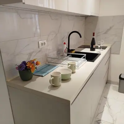 a white kitchen with a sink and a counter at Cera luxe apartment 2 in Soko Banja
