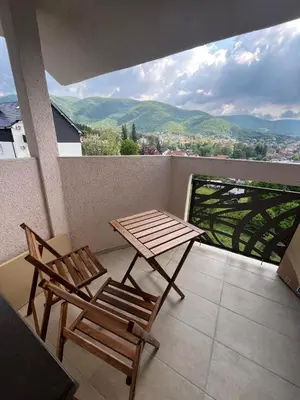 a table and two chairs on a balcony with a view at Apartman Djordjevic in Soko Banja