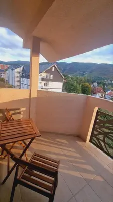 a balcony with a wooden bench and a table at Apartman Djordjevic in Soko Banja